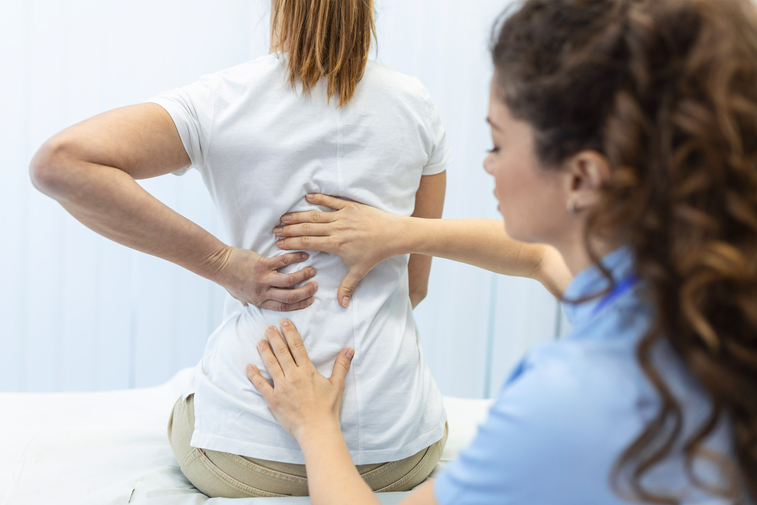 physiotherapist-doing-healing-treatment-womans-back-back-pain-patient-treatment-medical-doctor-massage-therapistoffice-syndrome
